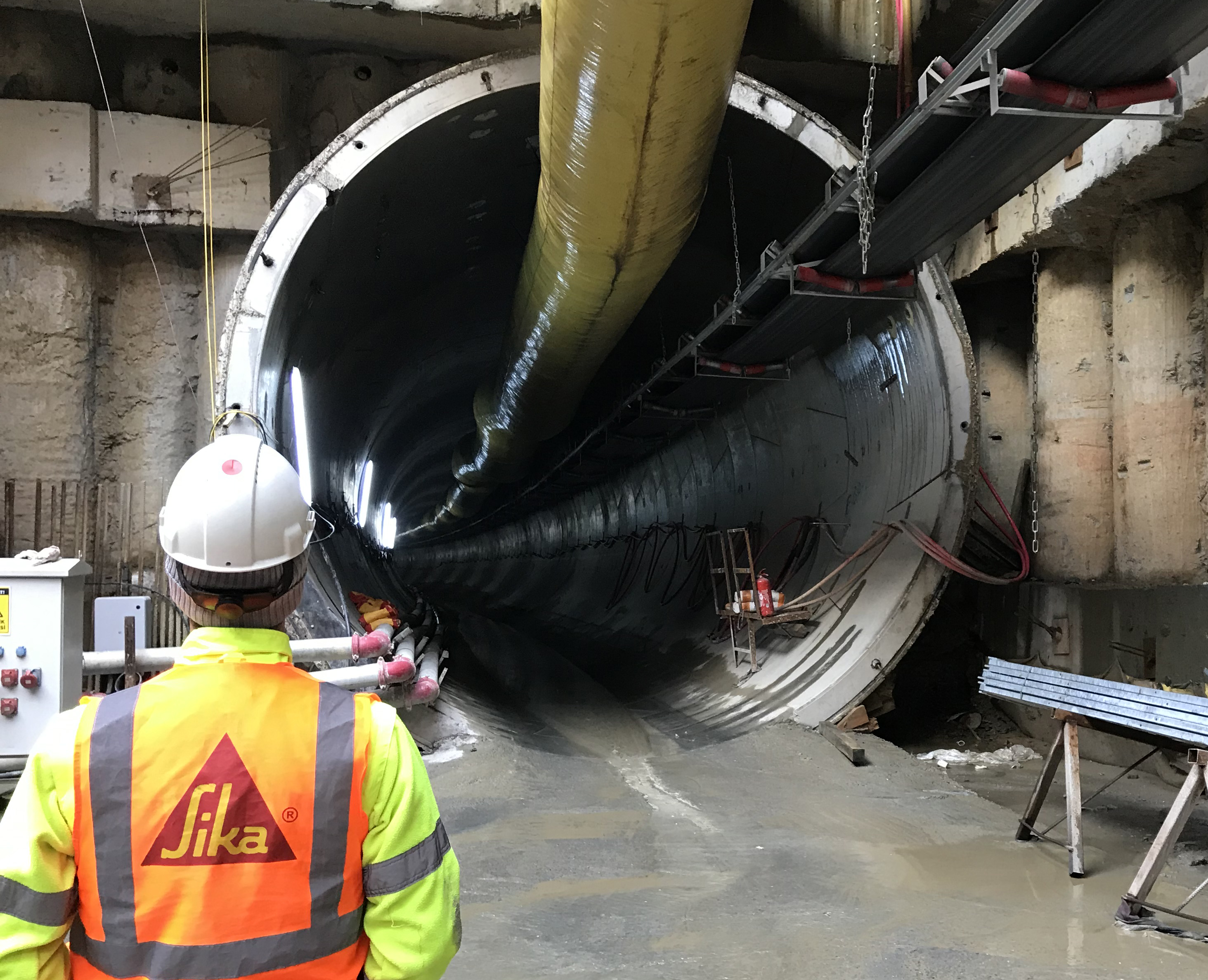 Sika engineer standing next to tunnel boring machine in tunnel construction